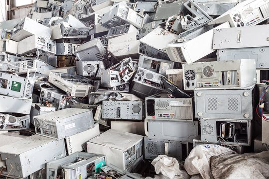 Image depicting a large pile of outdated IT equipment, including computers, monitors, and servers, awaiting responsible disposal or recycling.