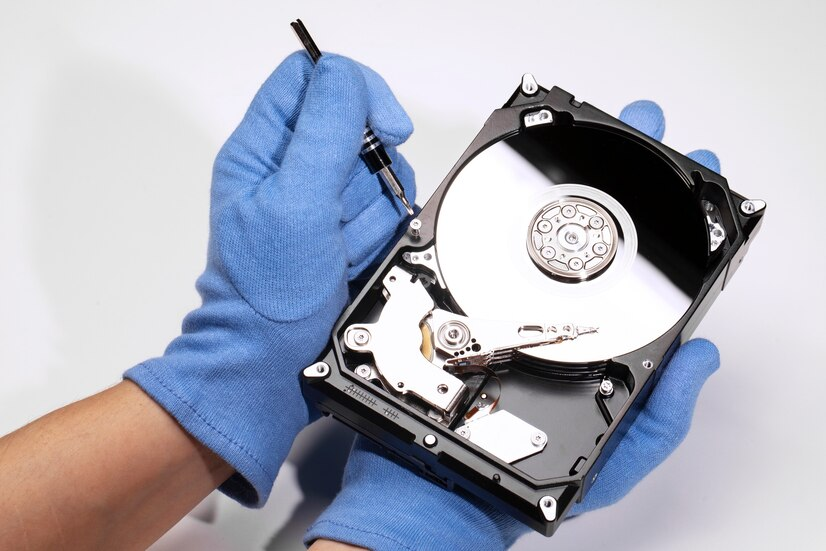 person taking apart a hdd for a part of a data destruction program